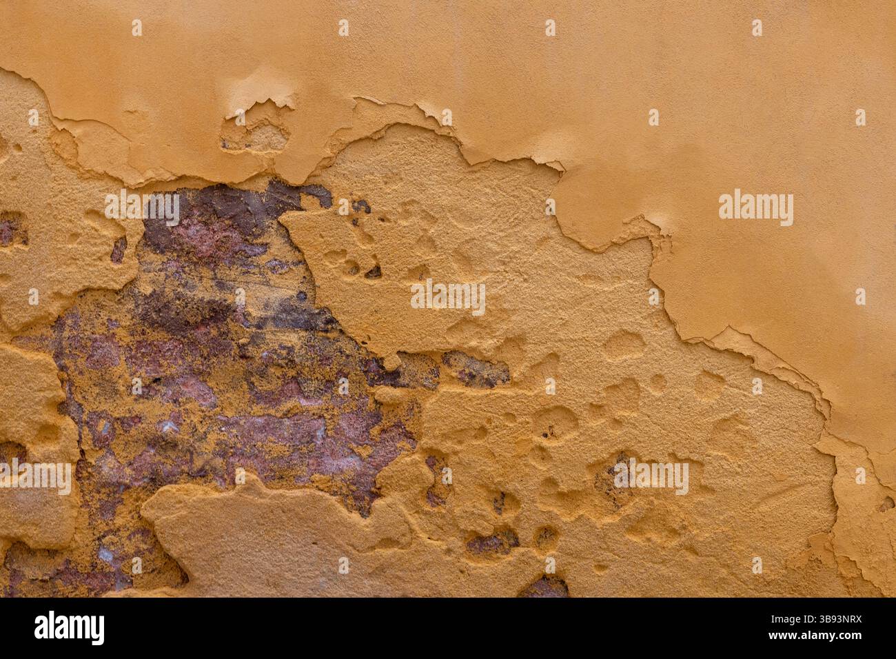 Peeling Yellow Plaster on Brick Wall Stock Photo