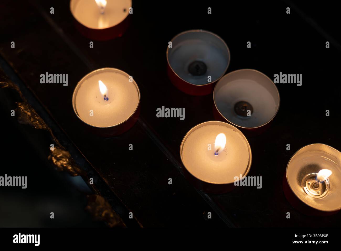 Burning Tealight Candles in Dark Interior Stock Photo