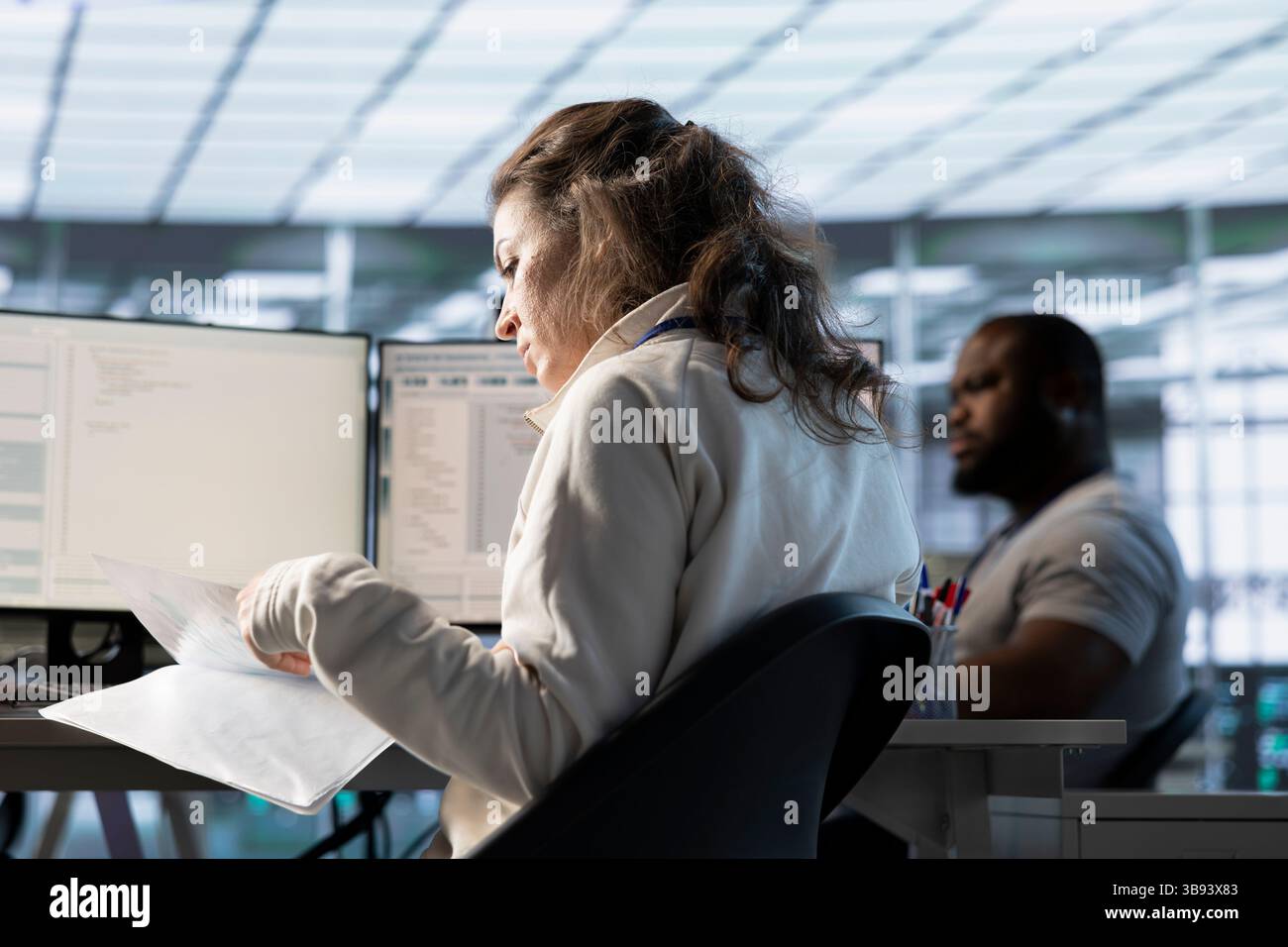 Woman overseeing server room, reading documentation paperwork ...
