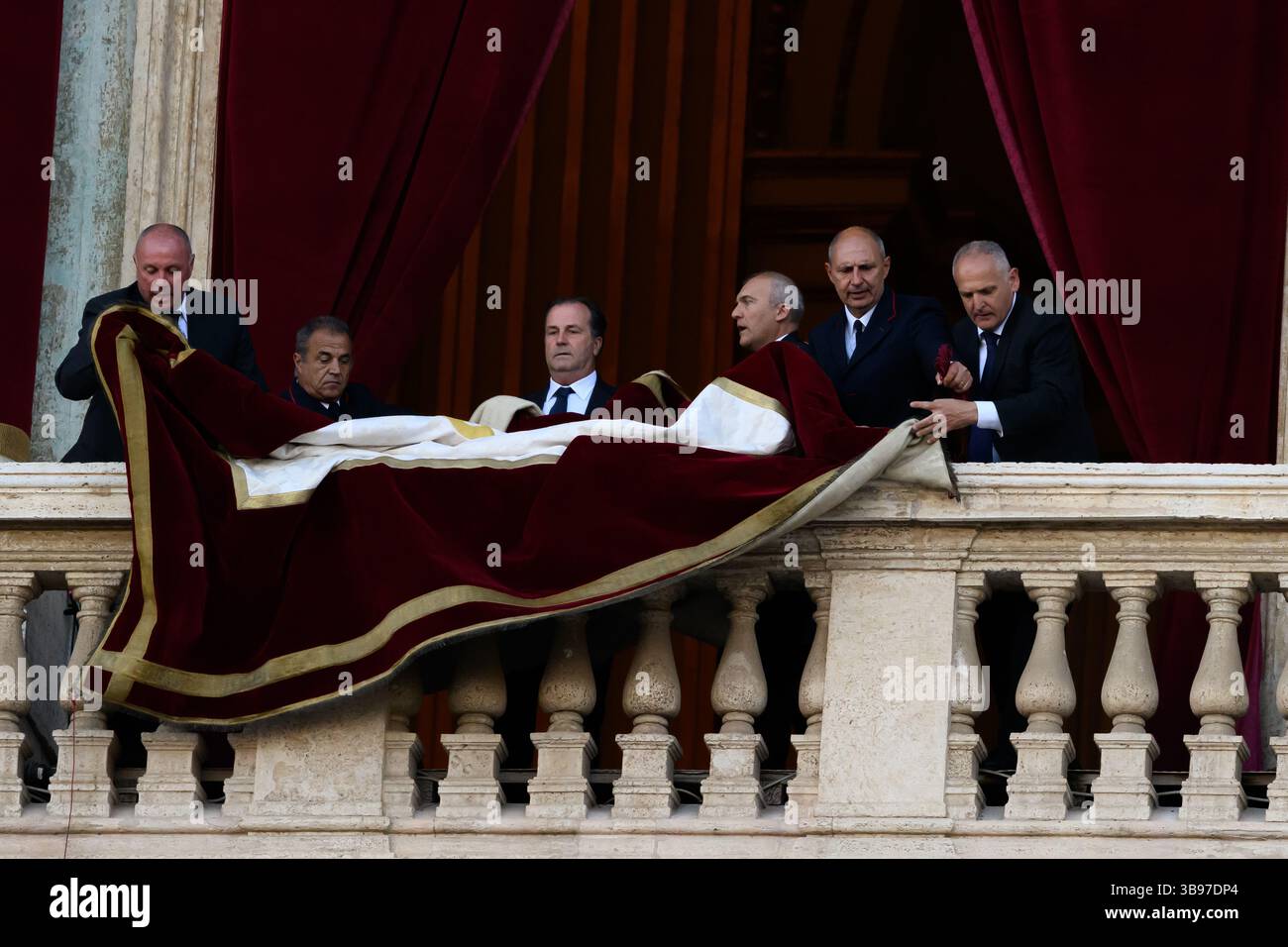 Vatican City, Italy. 08th May, 2025. Vatican staff unfurl the papal banner before the newly elected Pope Leo XIV, the American Robert Prevost, steps onto the balcony of St. Peter's Basilica in Vatican city on May 8, 2025. Credit: Insidefoto/Alamy Live News Stock Photo