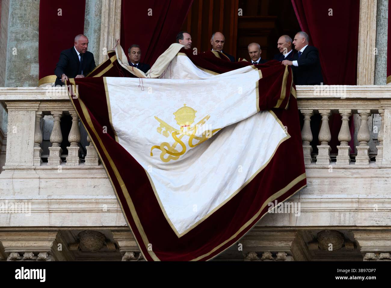Vatican City, Italy. 08th May, 2025. Vatican staff unfurl the papal banner before the newly elected Pope Leo XIV, the American Robert Prevost, steps onto the balcony of St. Peter's Basilica in Vatican city on May 8, 2025. Credit: Insidefoto/Alamy Live News Stock Photo