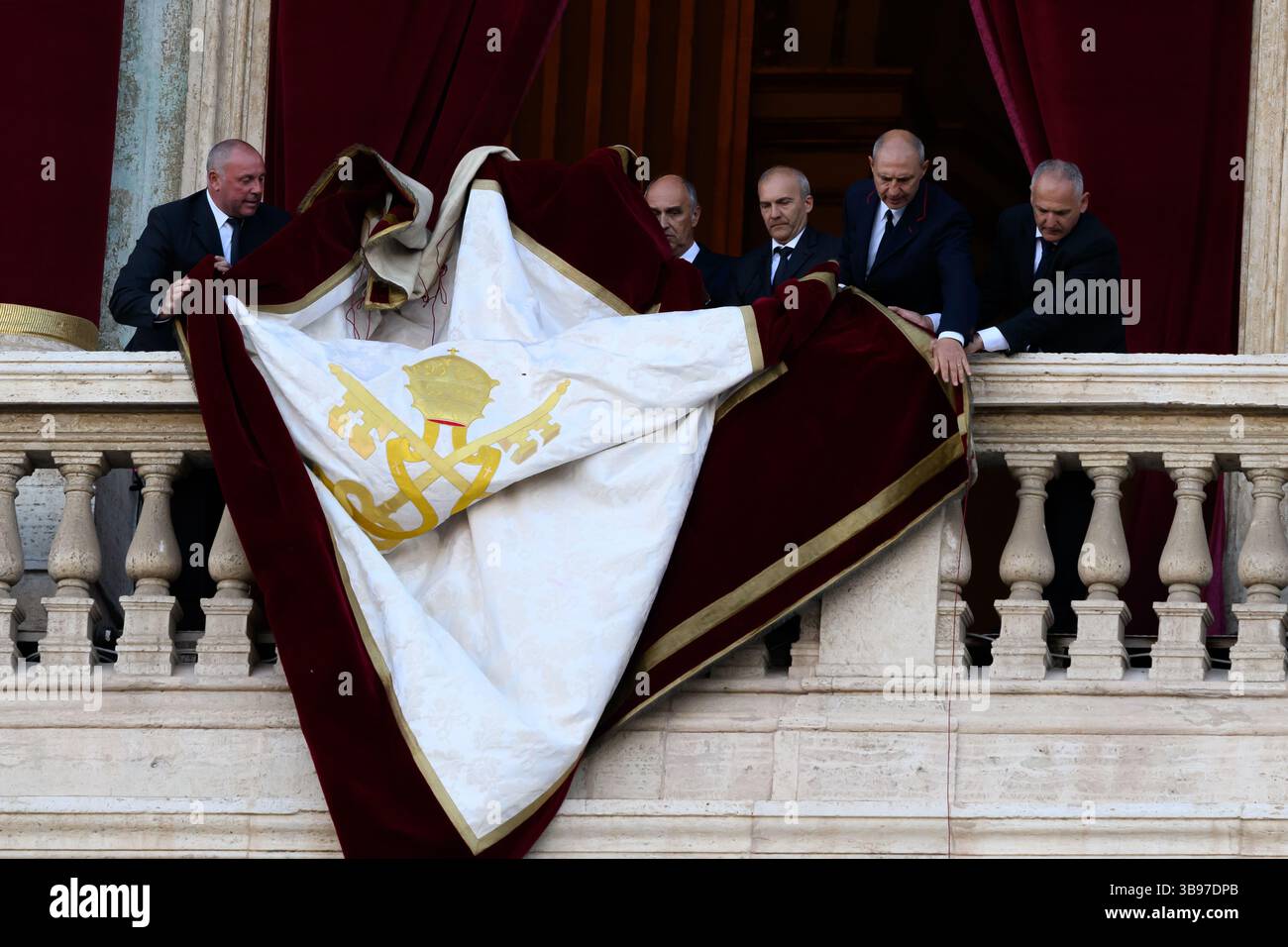 Vatican City, Italy. 08th May, 2025. Vatican staff unfurl the papal banner before the newly elected Pope Leo XIV, the American Robert Prevost, steps onto the balcony of St. Peter's Basilica in Vatican city on May 8, 2025. Credit: Insidefoto/Alamy Live News Stock Photo