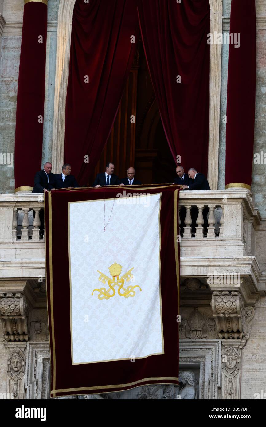 Vatican City, Italy. 08th May, 2025. Vatican staff unfurl the papal banner before the newly elected Pope Leo XIV, the American Robert Prevost, steps onto the balcony of St. Peter's Basilica in Vatican city on May 8, 2025. Credit: Insidefoto/Alamy Live News Stock Photo