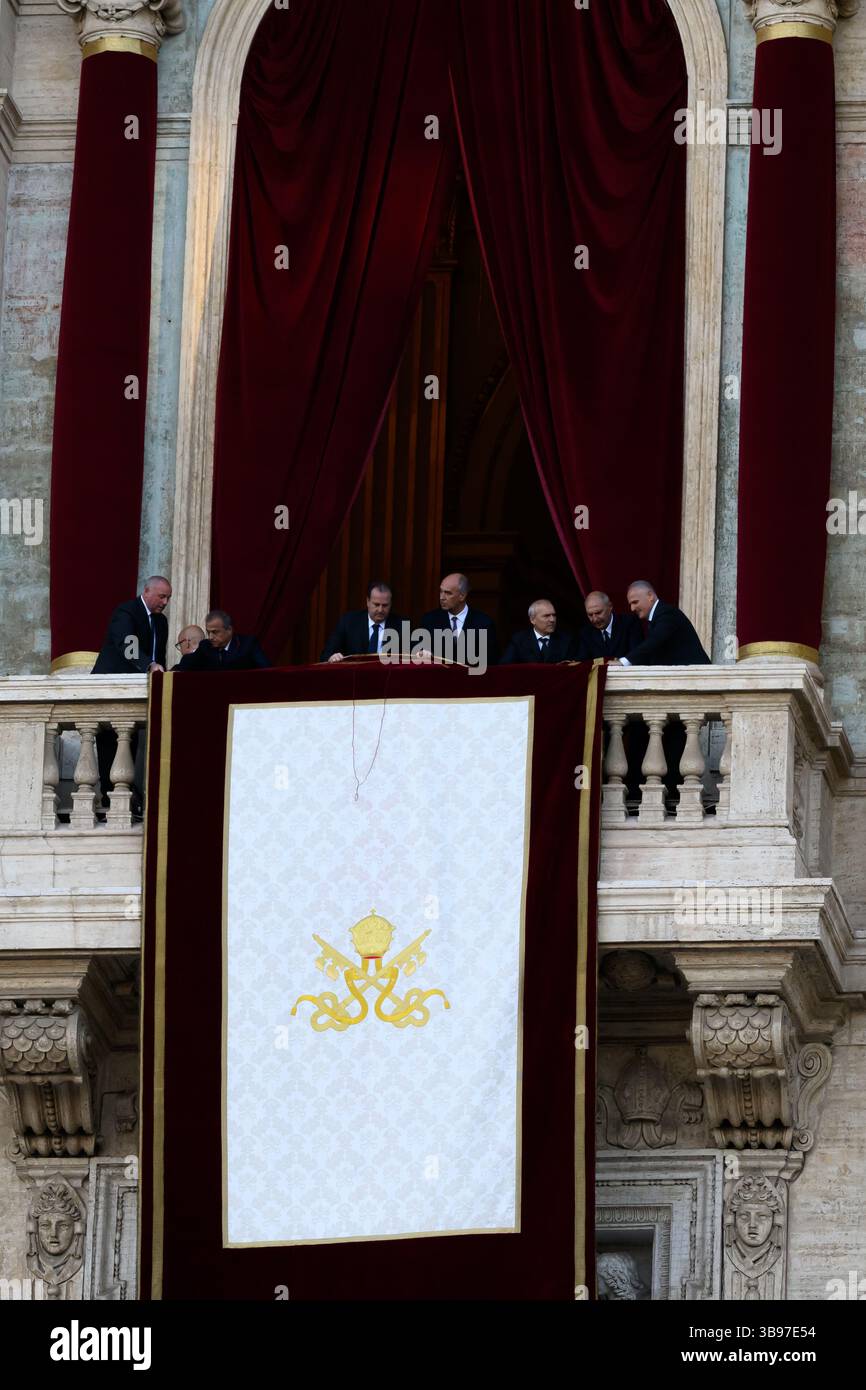 Vatican City, Italy. 08th May, 2025. Vatican staff unfurl the papal banner before the newly elected Pope Leo XIV, the American Robert Prevost, steps onto the balcony of St. Peter's Basilica in Vatican city on May 8, 2025. Credit: Insidefoto/Alamy Live News Stock Photo