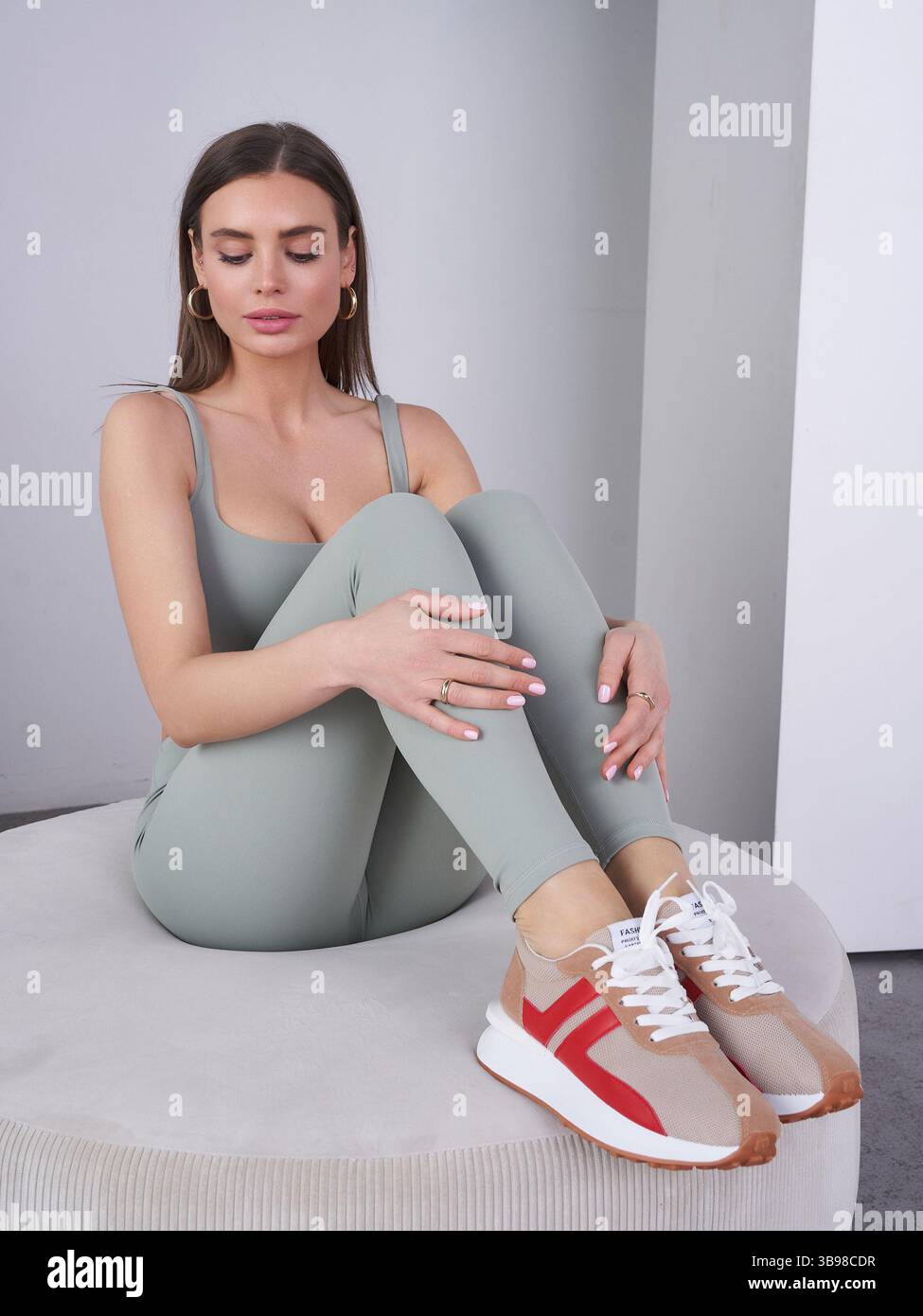 Elegant model showcases modern fashion in a minimalist studio setting ...