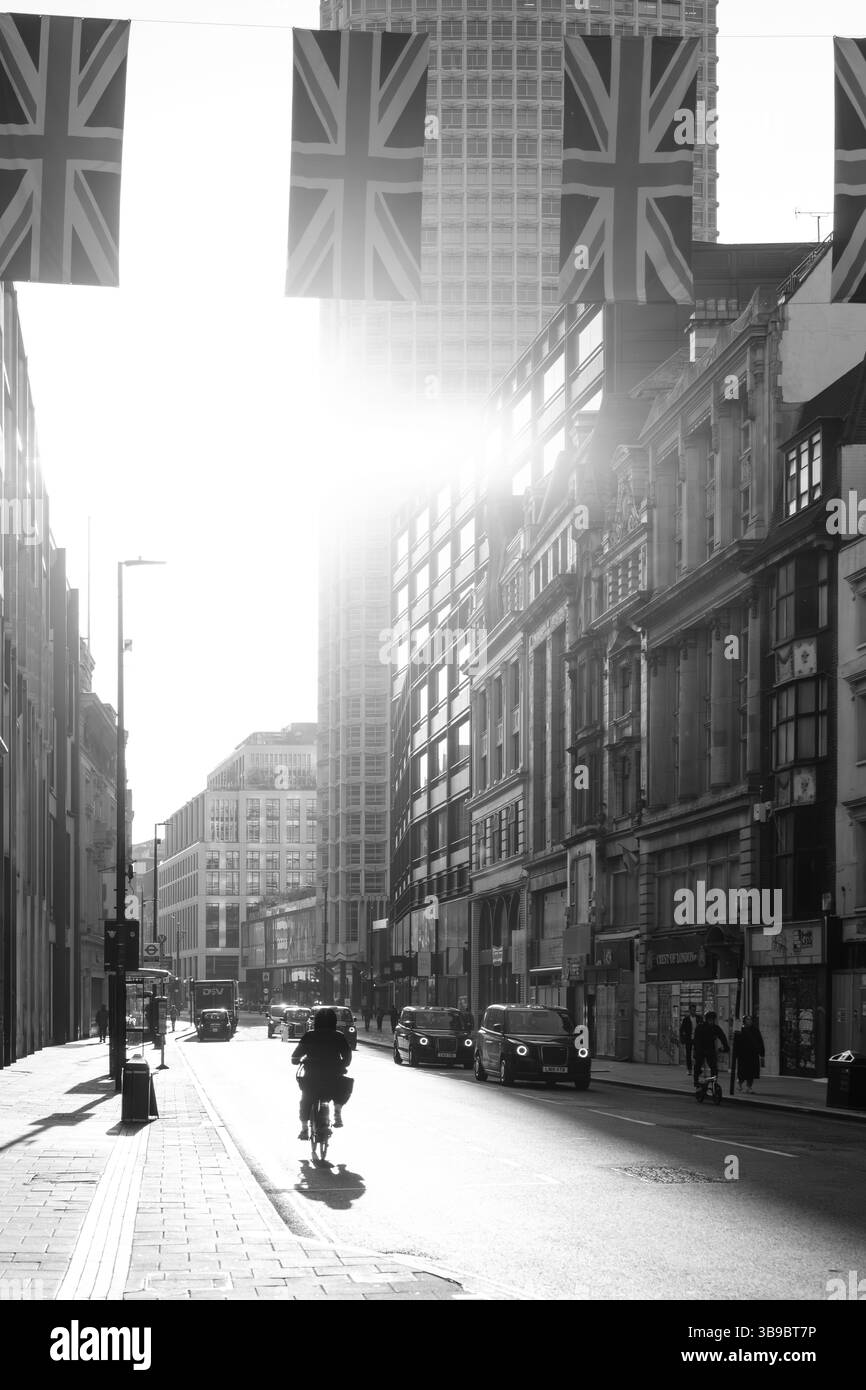 London, England - 28th April 2025: Early morning sunshine illuminates Union Jacks hanging across Oxford Street in London as the first commuters make t Stock Photo