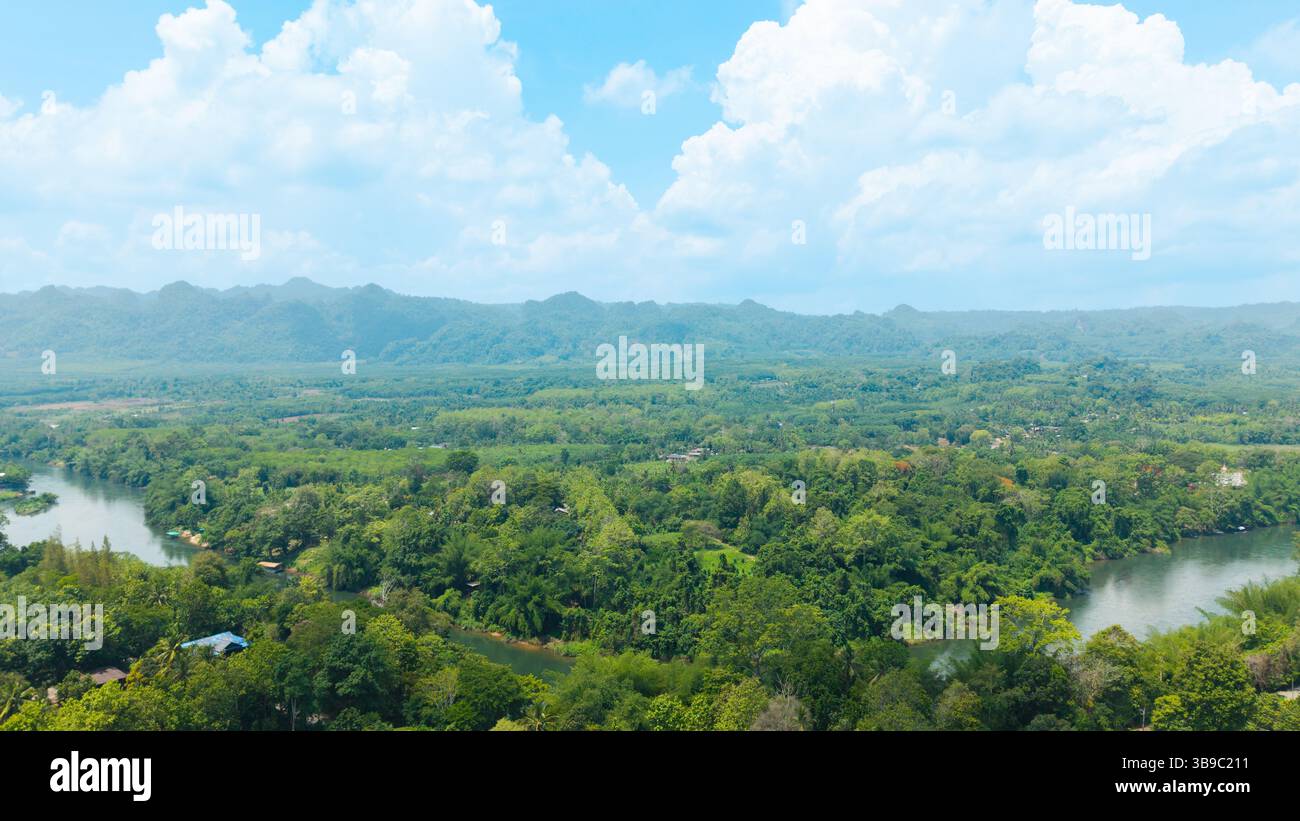 Aerial view of a river cutting through a forest and a clear cloudy sky ...
