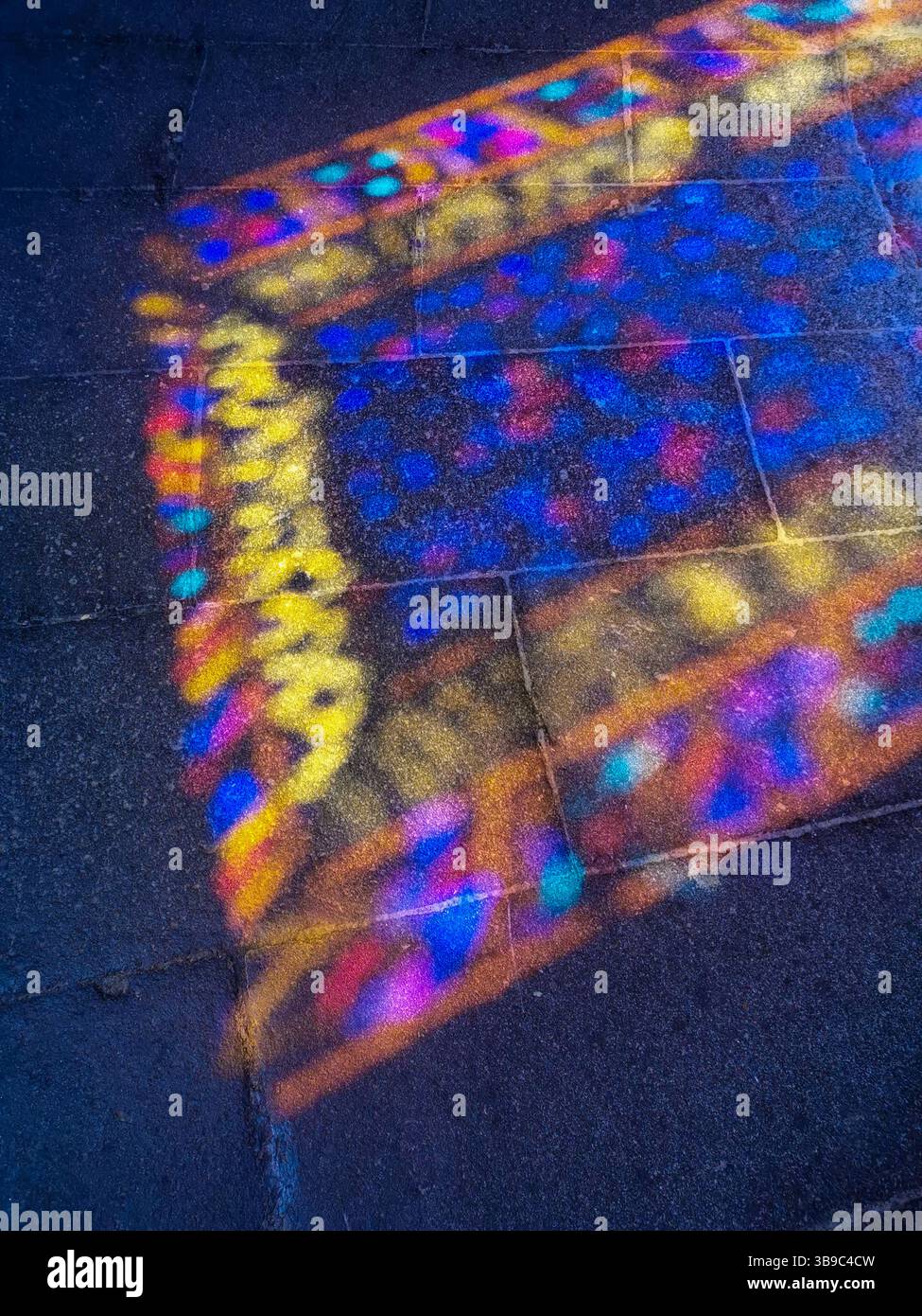 Issoire. Stained glass reflection illuminating the stone floor inside Abbey of Saint-Austremoine in Auvergne, Puy de Dome.  France - Smartphone Captured Stock Image