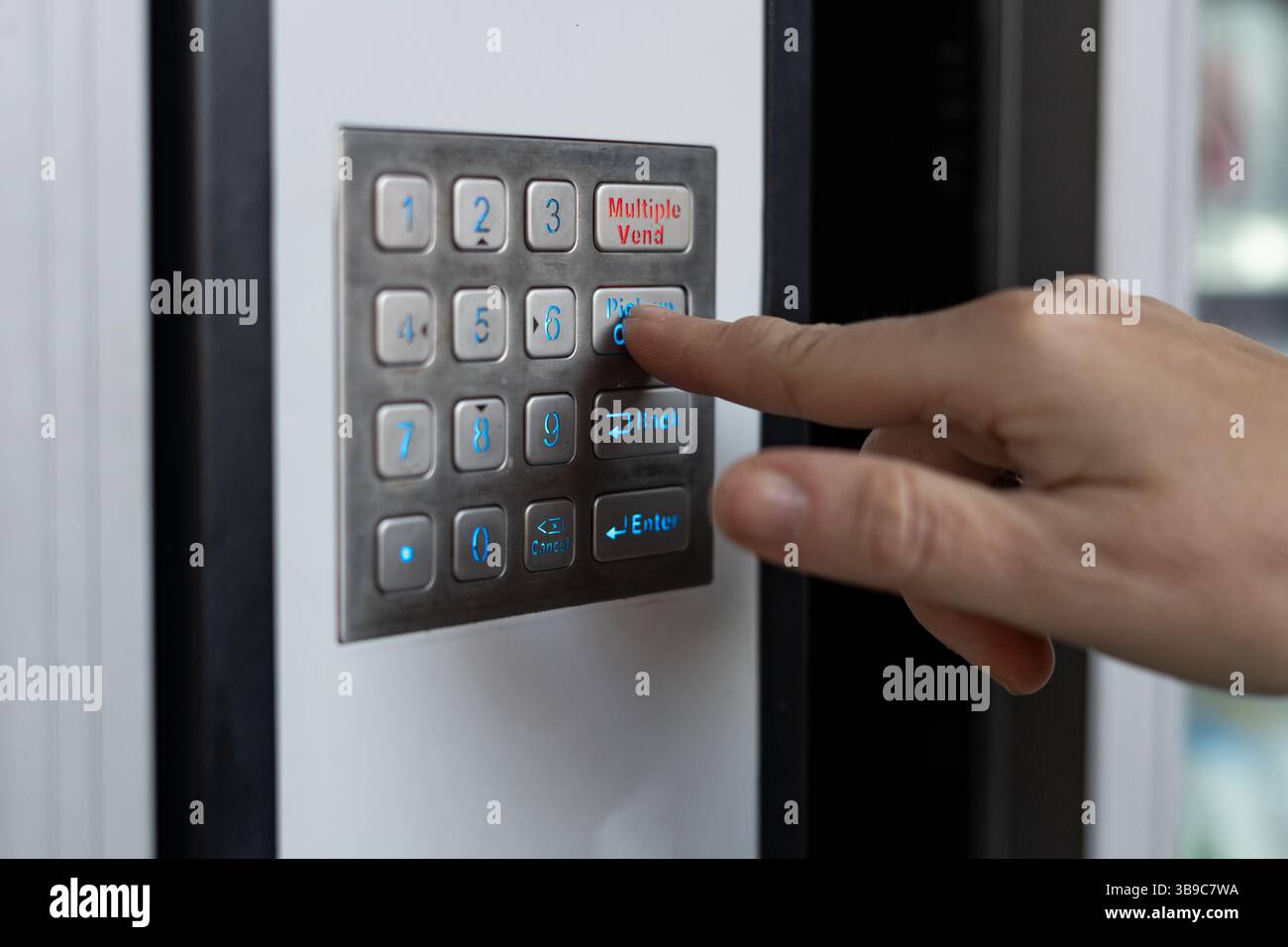 Customer pressing button on vending machine keypad Stock Photo