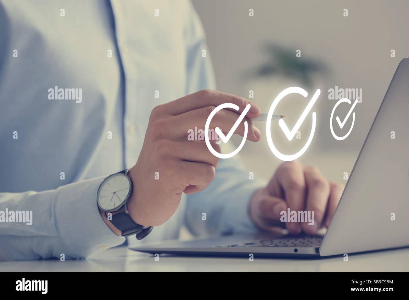 Approved. Man using laptop and touching virtual screen with check marks at table, closeup Stock Photo