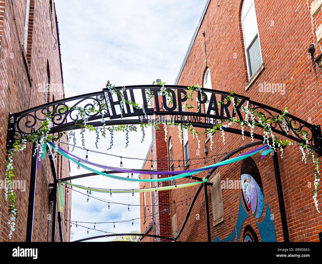 Mount Vernon, Iowa, USA - May 4, 2025: Hilltop Park Archway Sign Between Brick Buildings Stock Photo