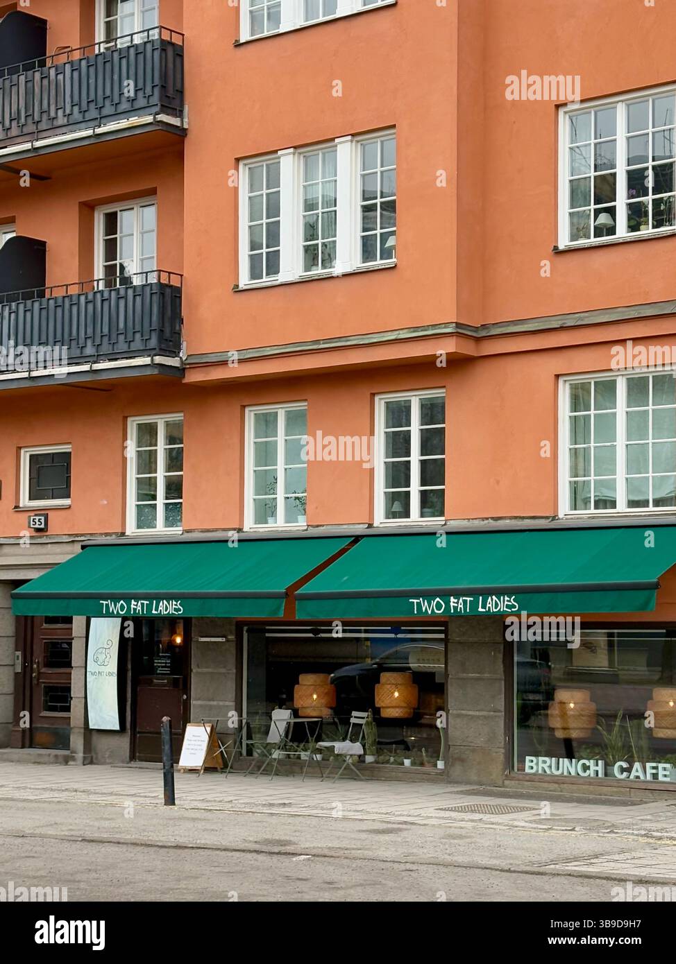 Colorful Café Exterior with Green Awnings in Stockholm, Sweden - Smartphone Captured Stock Image