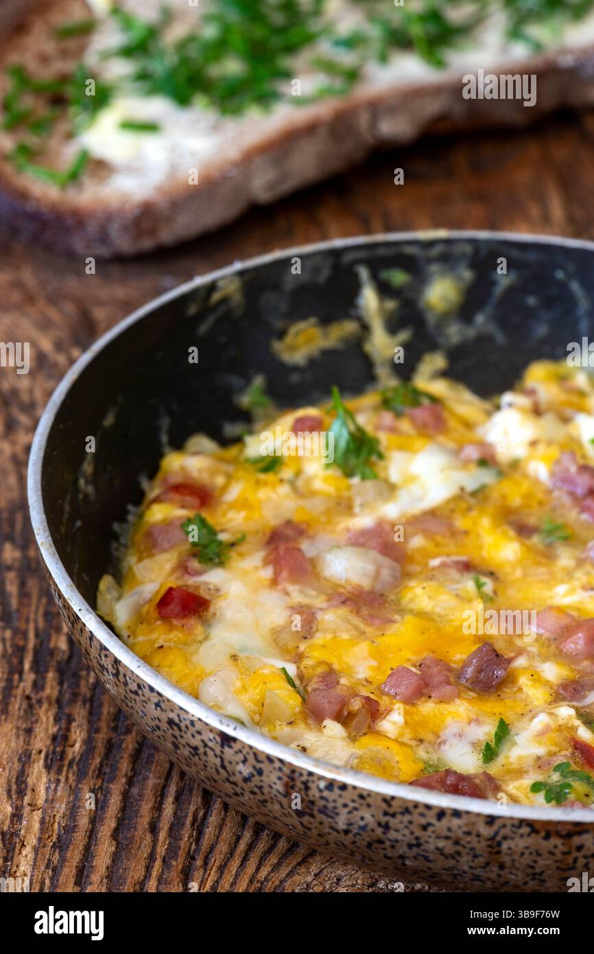 Scrambled eggs in a pan on wood Stock Photo