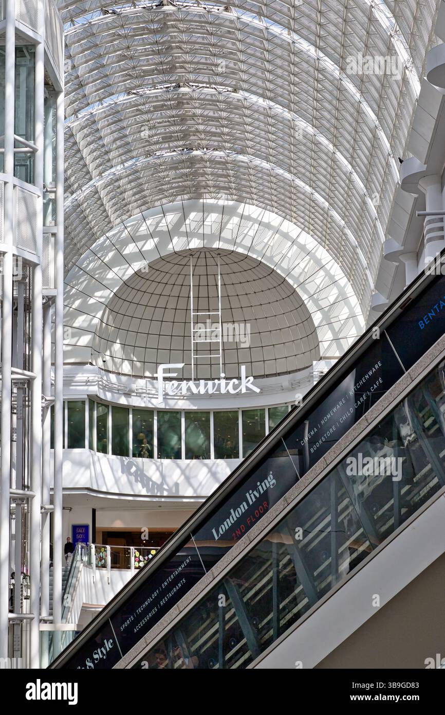Interior shot of a shopping center featuring a dome ceiling, escalators, elevator shaft and storefront of a Fenwick store at Bentall Centre in Kingsto Stock Photo