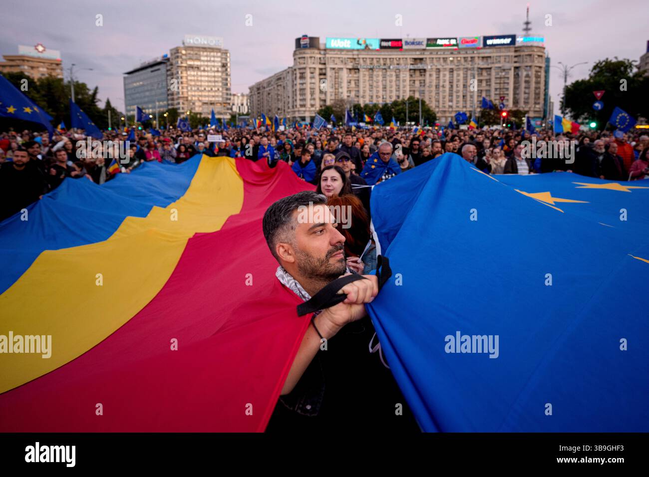 Demonstrators hold large Romanian and European Union flags during a pro ...