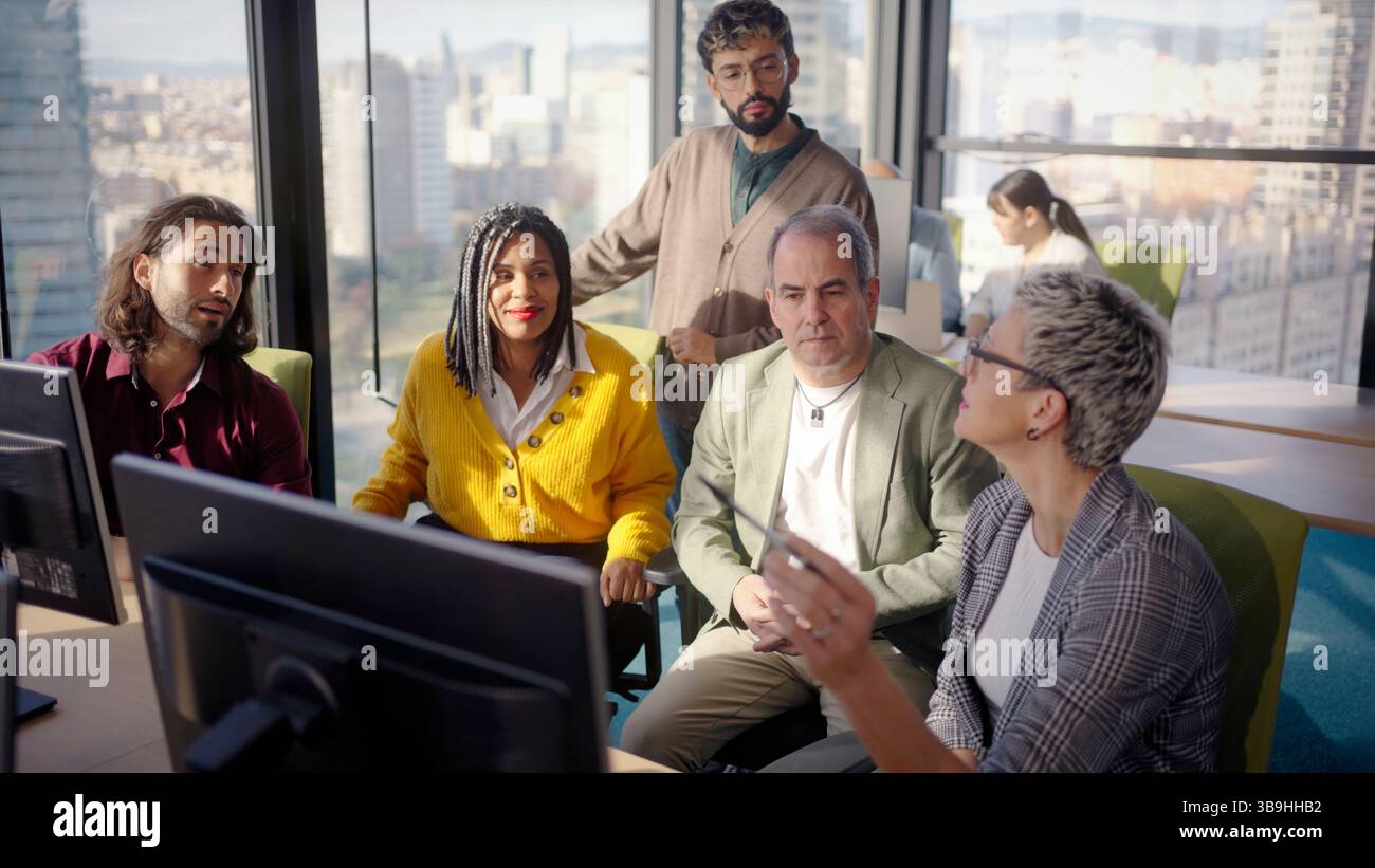 Business team analyzing data on computer in modern office Stock Photo