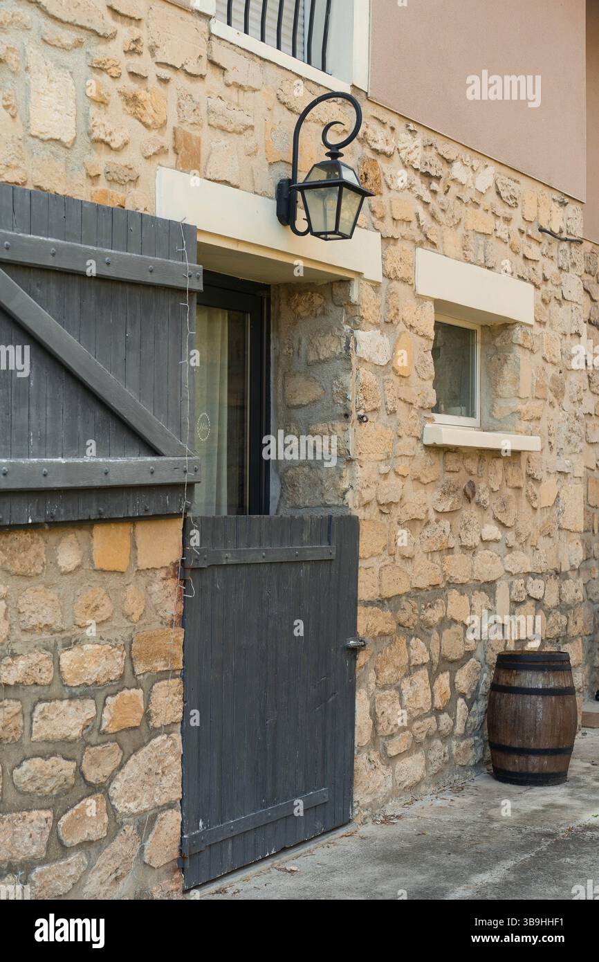 Stone house facade with wooden door and rustic barrel Stock Photo - Alamy