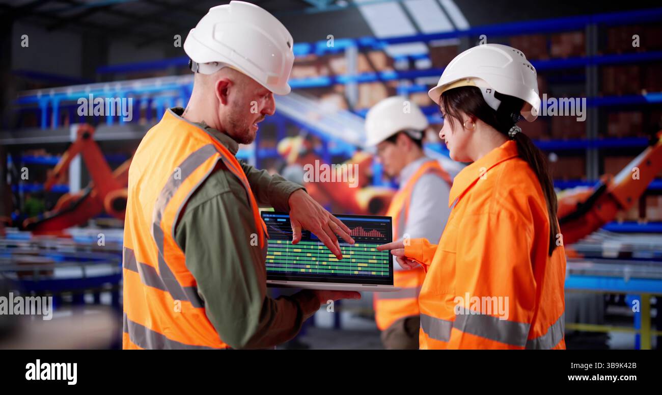 Hispanic Warehouse Engineer Manages Logistics Team Using Laptop For Inspection Stock Photo