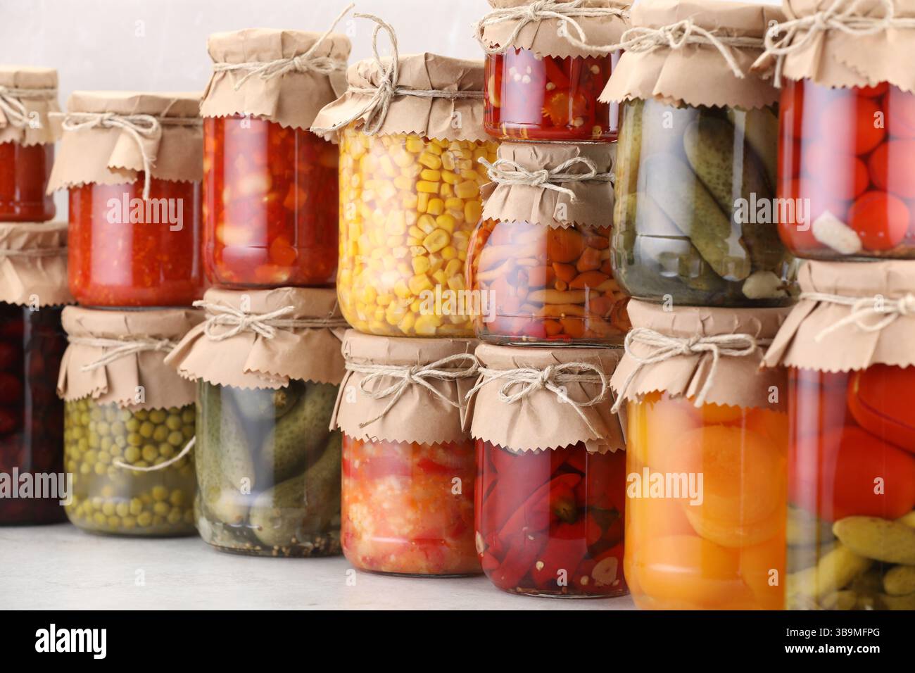 Many jars with different pickled products on light table Stock Photo