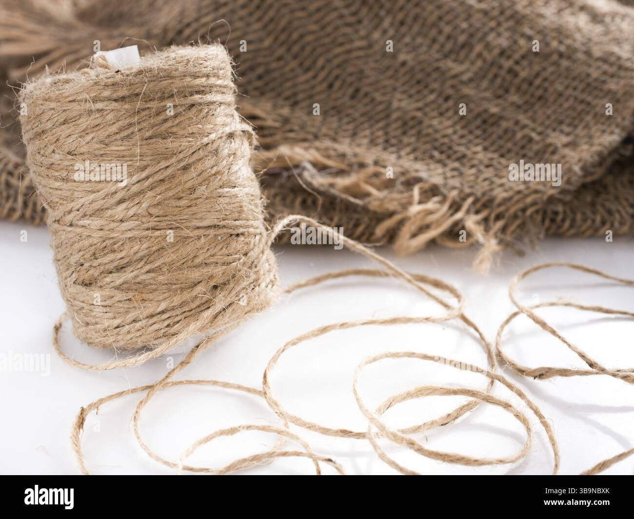 Skein of jute twine. Clew of natural rope. Roll of twine jute on sacking Stock Photo