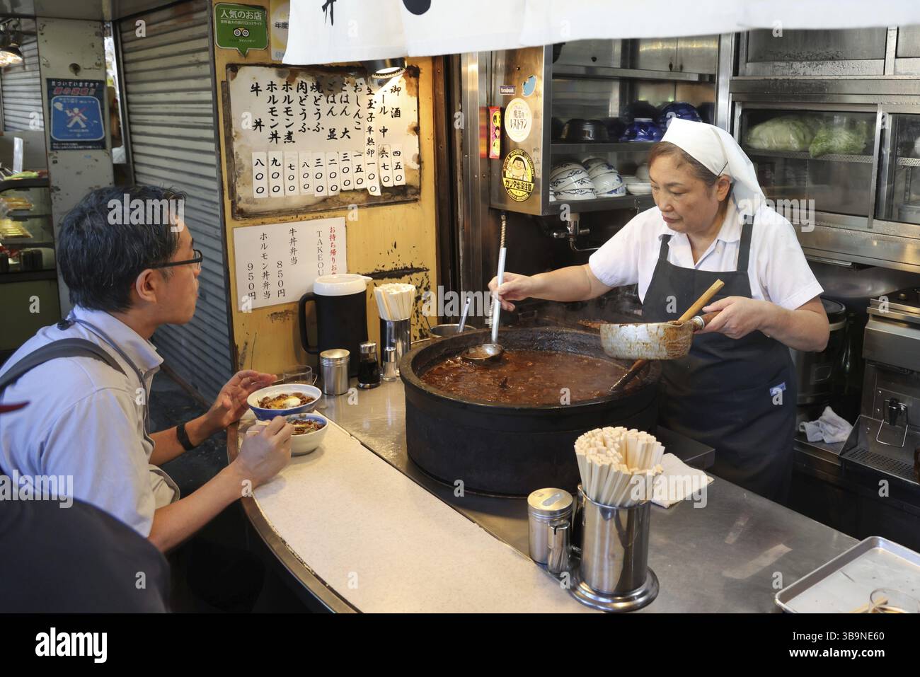 Woman serving beef stew in a roadside food stall in Outer Tsukiji Market area, Tsukiji, Chuo City, Tokyo, Japan, Asia Stock Photo