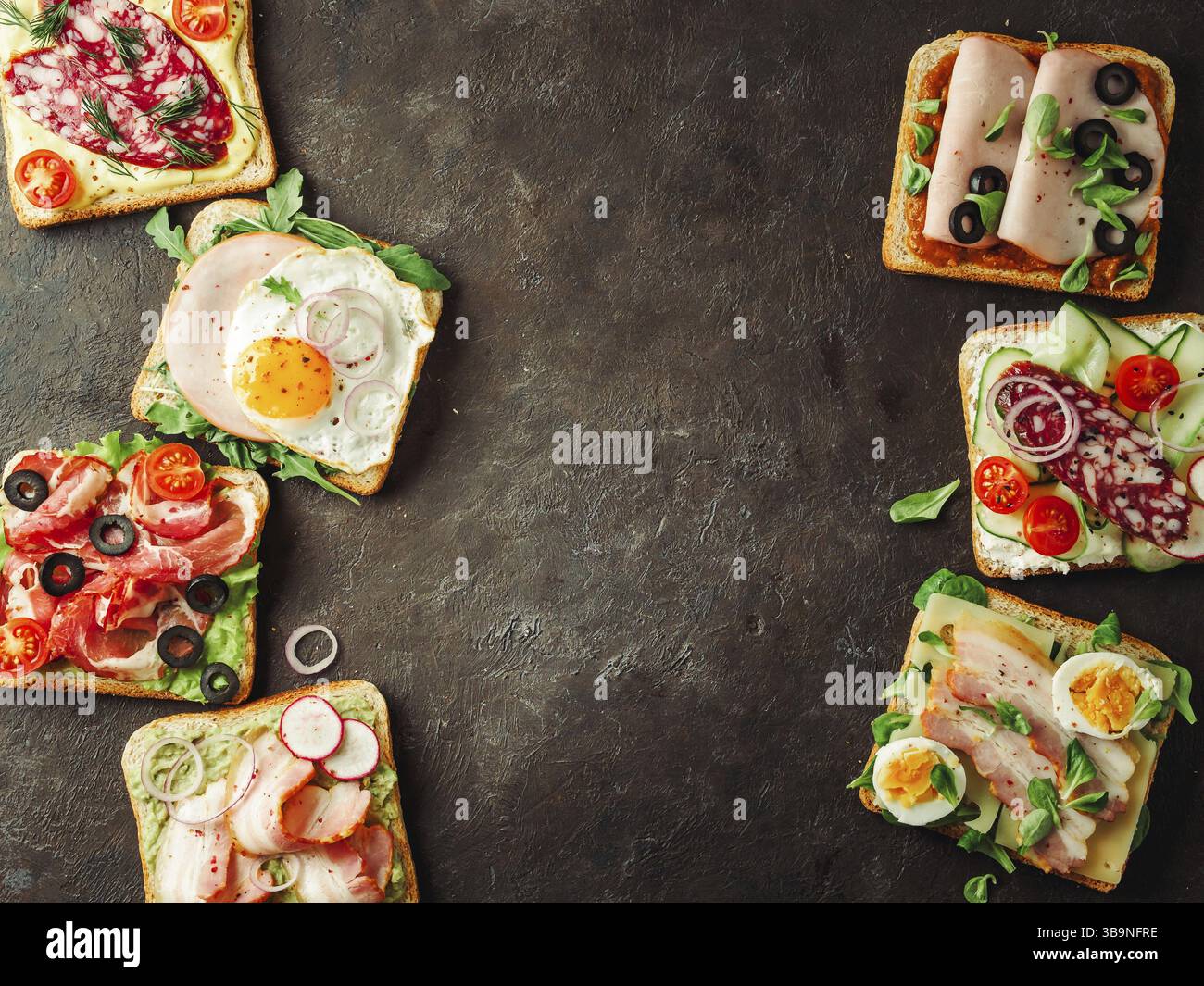 Set of eight different sandwiches with meat, copy space for design or text in center. Top view or flat lay. Assortment meat toasts on black background Stock Photo