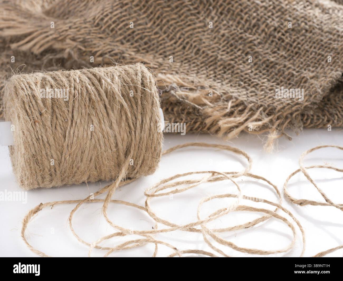 Skein of jute twine. Clew of natural rope. Roll of twine jute on sacking Stock Photo