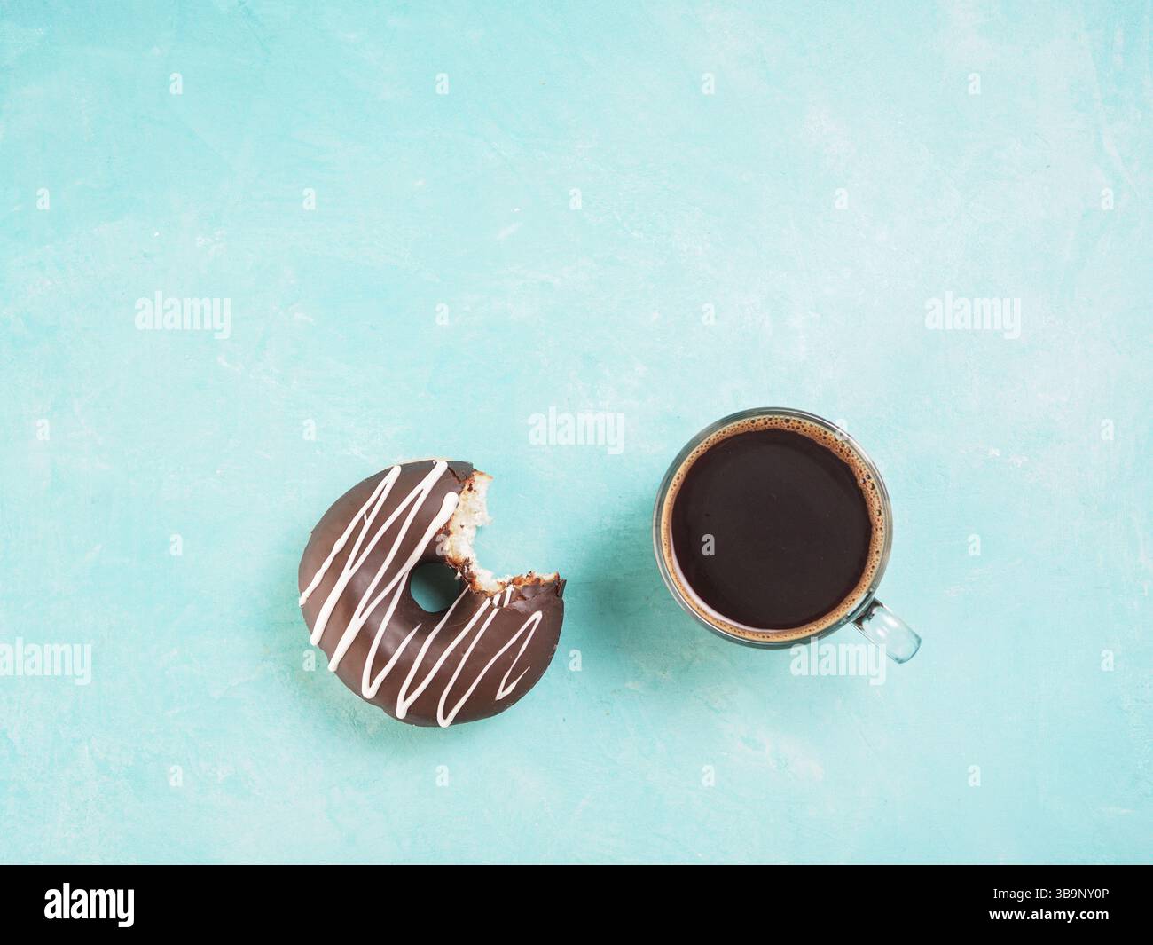 Top view of chocolate donut and coffee on blue concrete background with ...