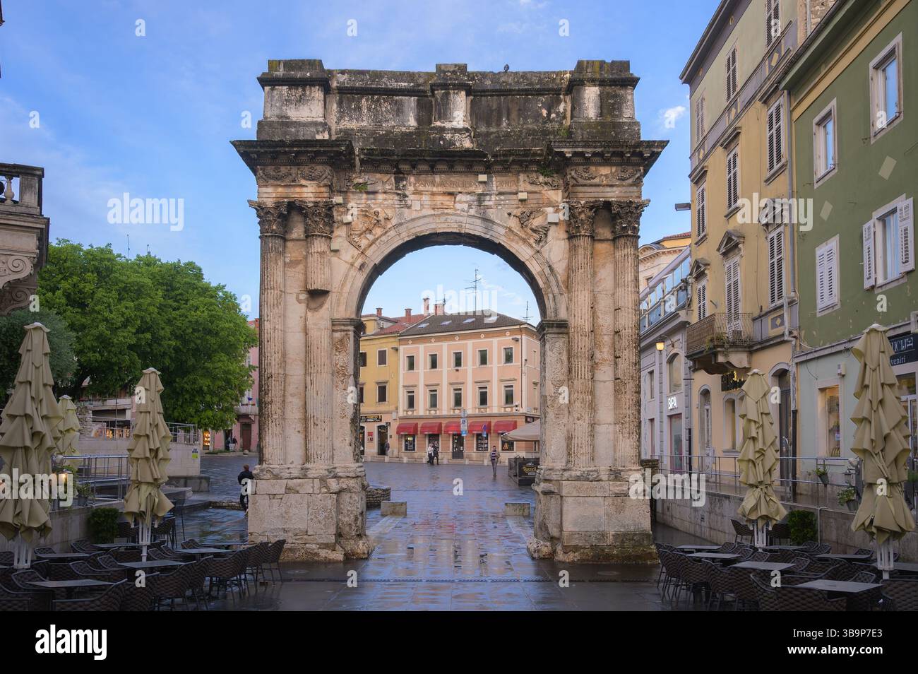 Visitors admire the ancient Roman Gate in Pula, Croatia, as the sun ...
