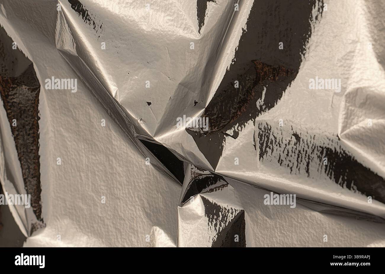 Silver foil with shiny, metallic texture creates a reflective, angular ...
