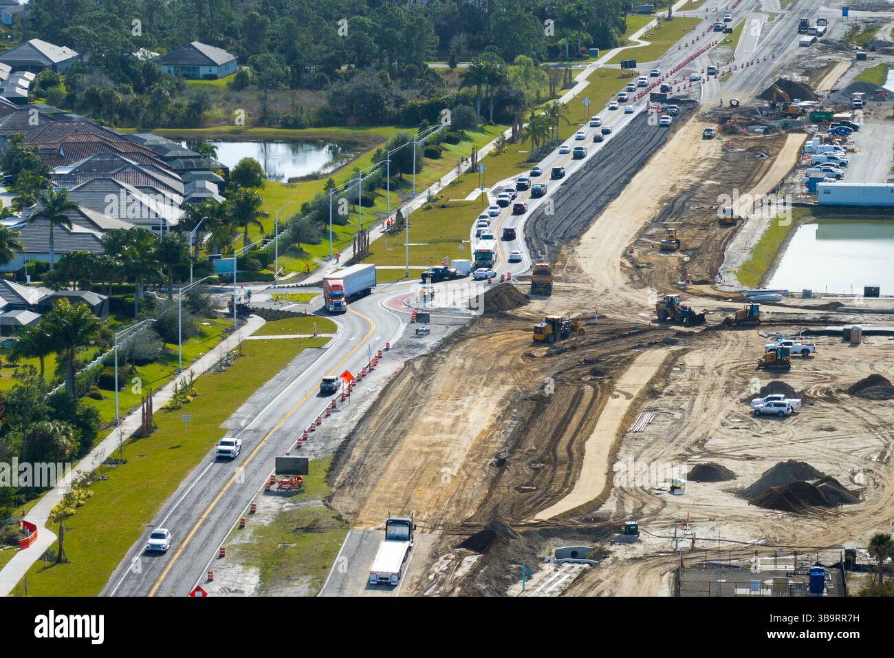 Driving traffic cars at roundabout intersection under construction ...