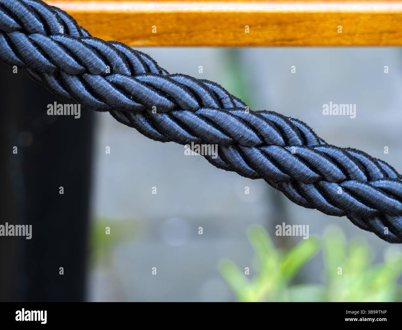 Resting Ropes Close-up of a thick, braided black rope with a smooth texture, resting ...