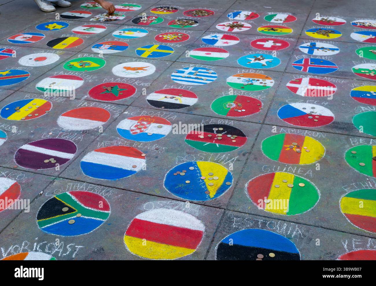 Chalk-painted world flags with coin donations on a Berlin sidewalk as ...
