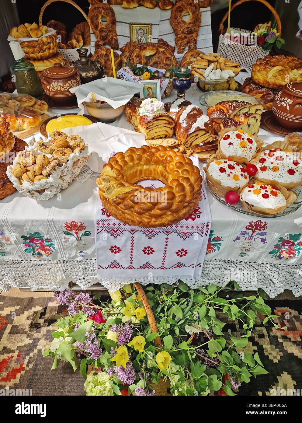 UNGHENI, MOLDOVA - MAY 04, 2025 Exposition of handmade bakery and different crafts. Traditional Moldovan festive setup with embroidered textiles and r - Smartphone Captured Stock Image