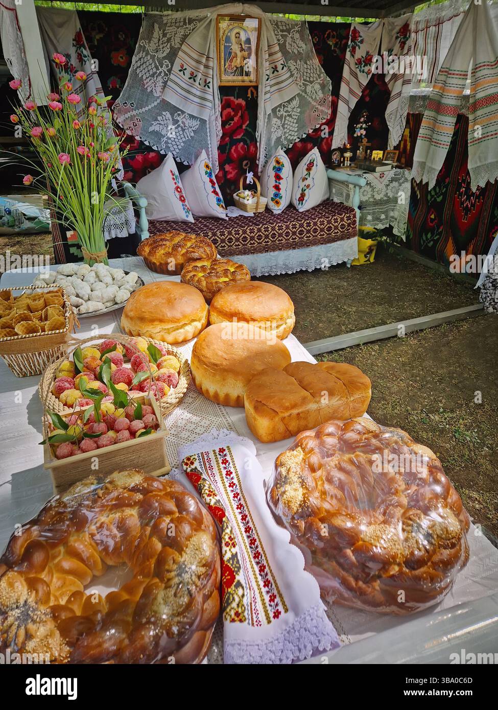 UNGHENI, MOLDOVA - MAY 04, 2025 Exposition of handmade bakery and different crafts. Traditional Moldovan festive setup with embroidered textiles and r - Smartphone Captured Stock Image