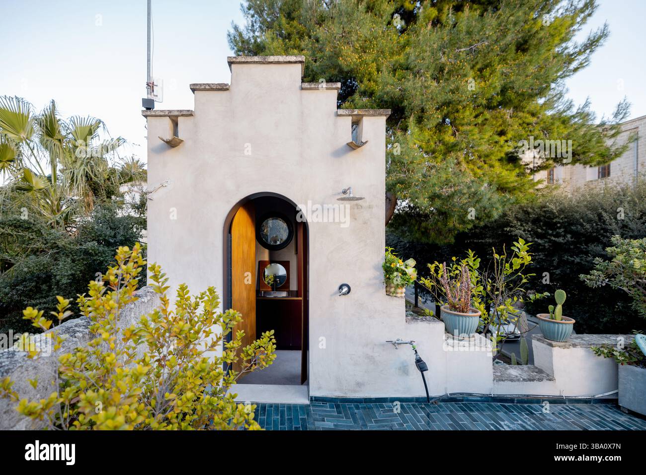 Picture of Stone rooftop shower entrance with round mirrors, potted plants and ...