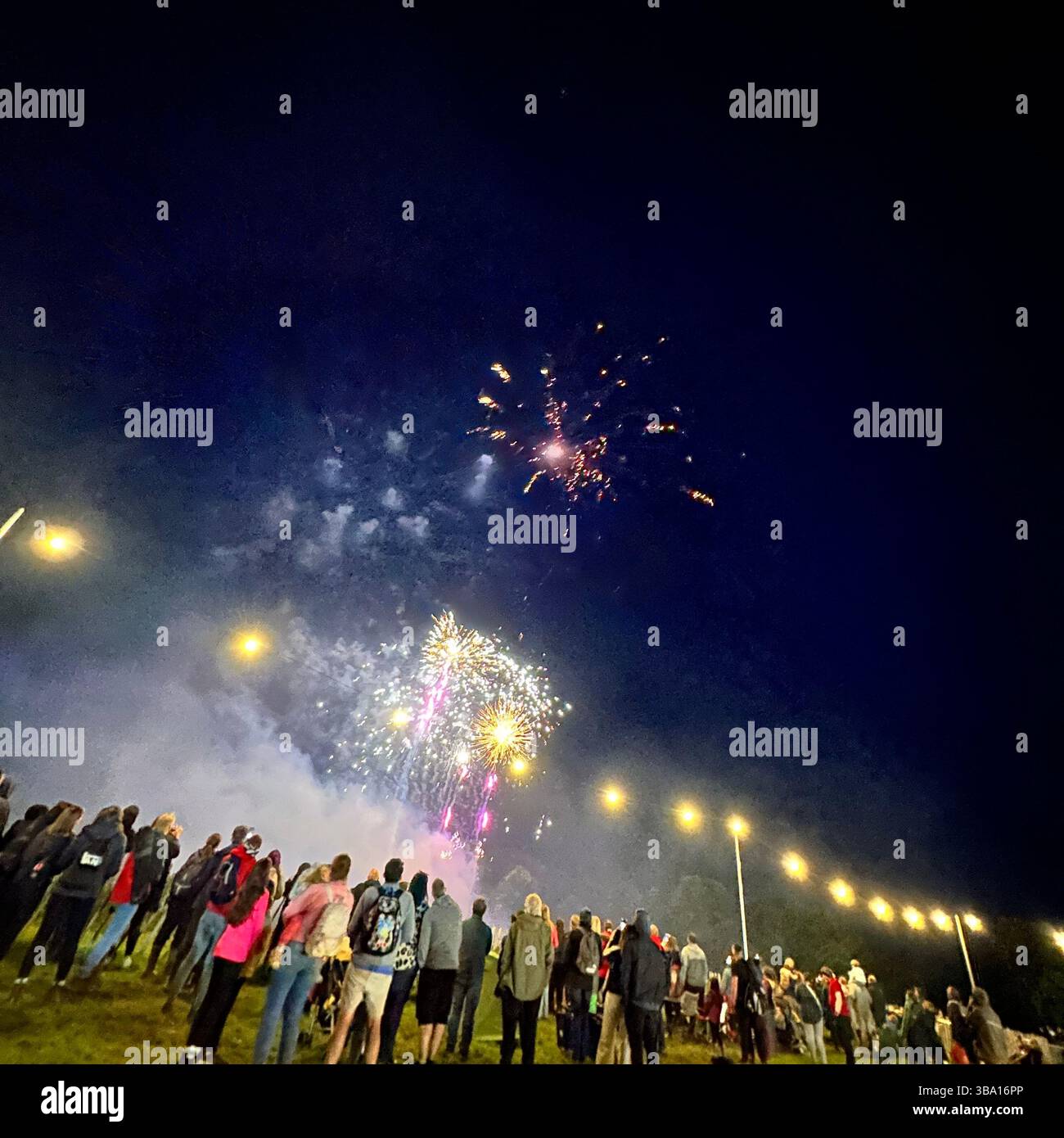 Fireworks display at Cheshire Balloon Fiesta, Bolesworth Estate, Tattenhall, UK, with crowd and festoon lights, 6 August 2023. Editorial use. - Smartphone Captured Stock Image