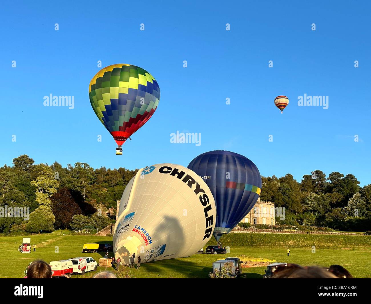 Hot air balloons lifting off and flying above the Bolesworth Estate during the Cheshire Balloon Fiesta, Tattenhall, England, August 6 2023. - Smartphone Captured Stock Image