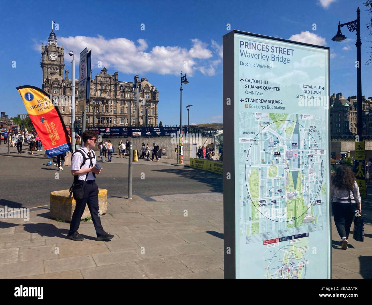 Visitor information board with city map and attractions on Princes Street at Waverley Bridge, vendor selling bus tour tickets, Edinburgh Scotland - Smartphone Captured Stock Image