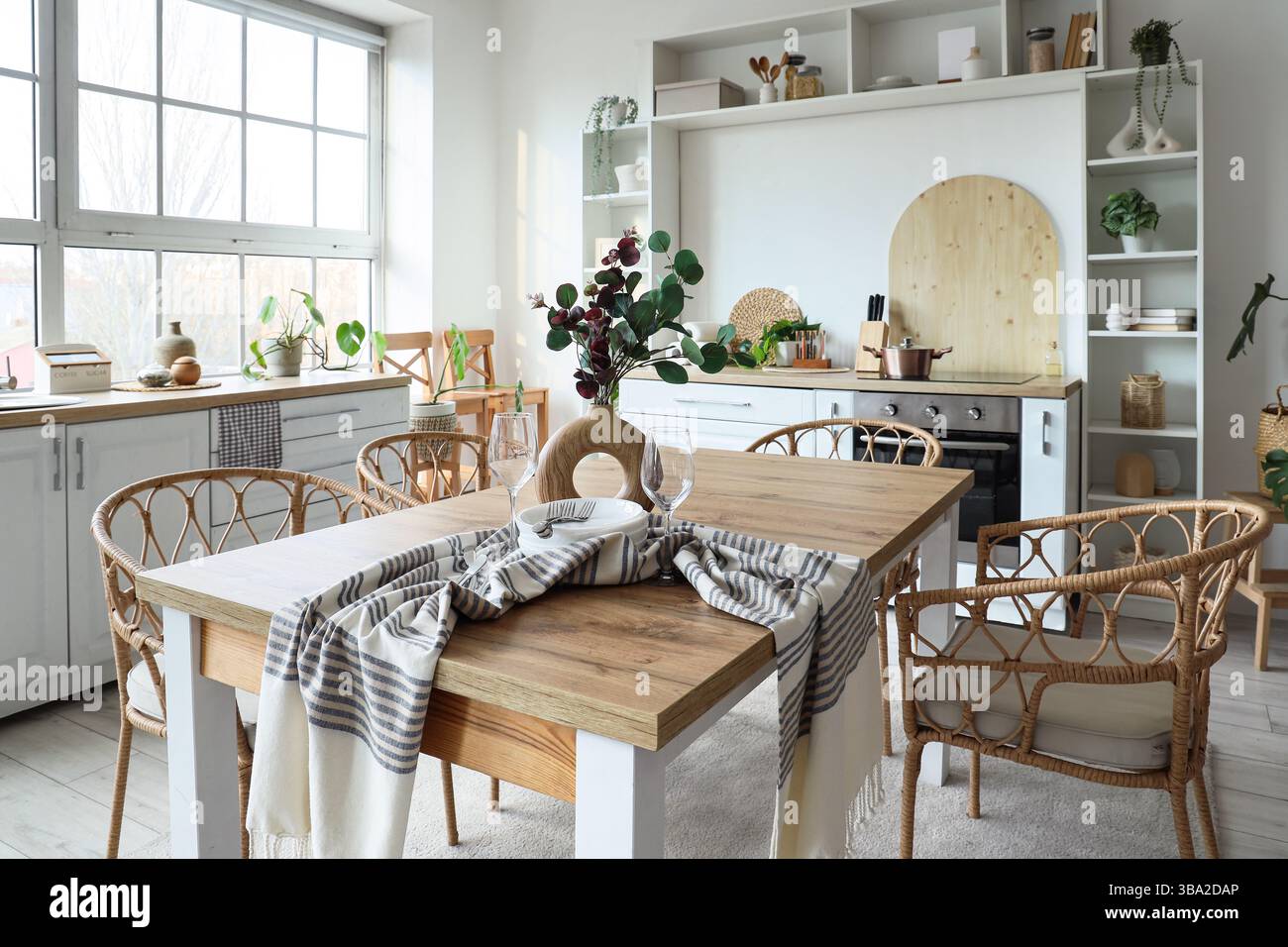 Interior of light kitchen with dining table, counters and shelf unit ...