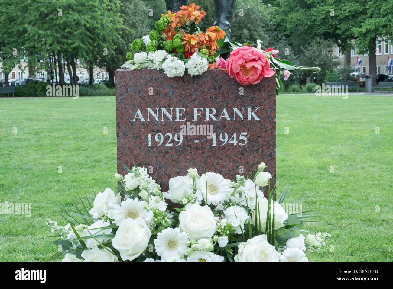 Pedestal under statue of Anne Frank on square Merwedeplein, Amsterdam. Flowers in the context of commemoration of the dead of World War II on May 4. Stock Photo