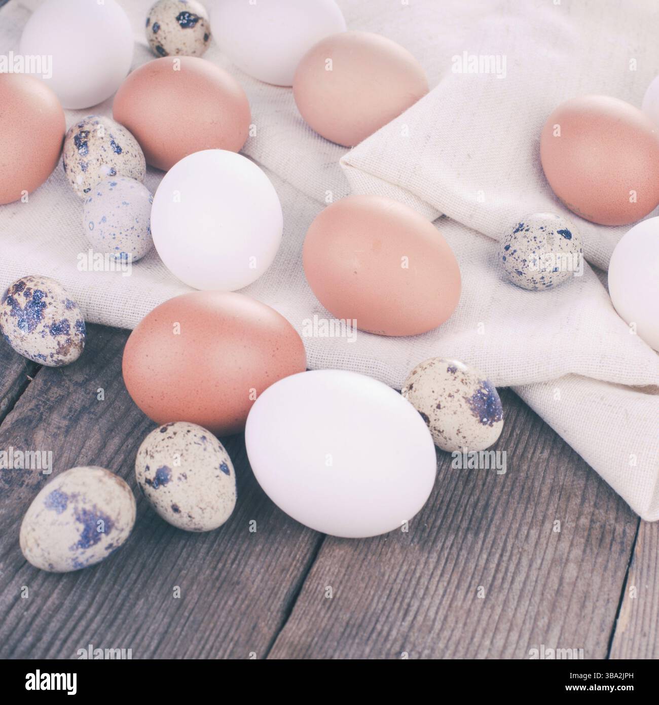 Eggs on textile tablecloth over rustic wooden table Stock Photo