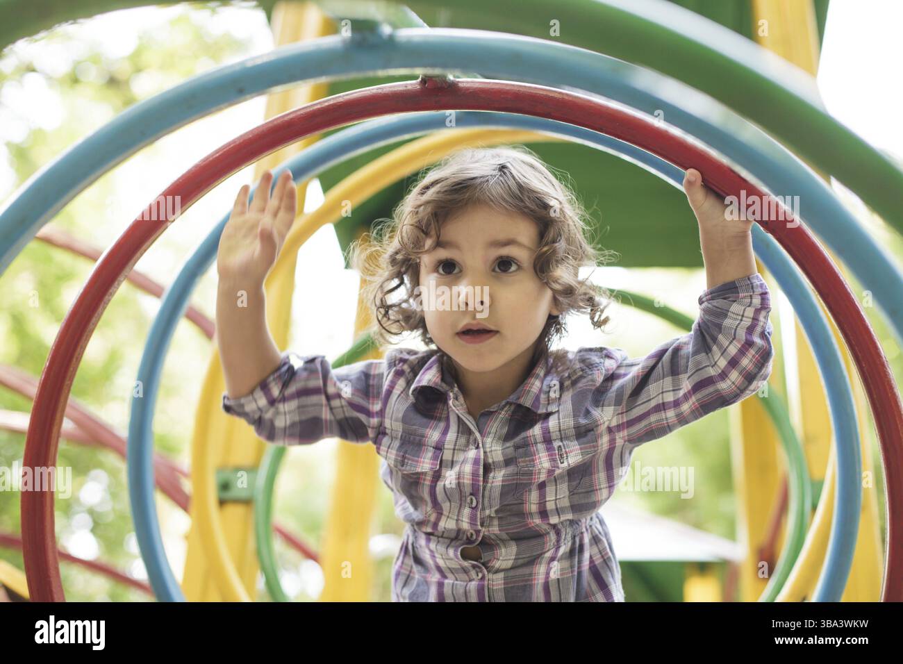 Kids Using Playground Rings Girl climbs at the playground, color metal sport rings Stock Photo - Alamy