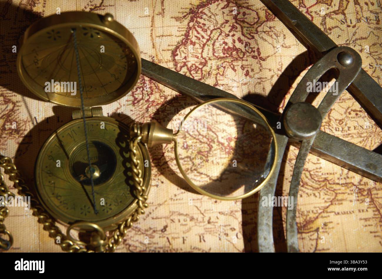 Old compass and magnifying glass lying on the map Stock Photo