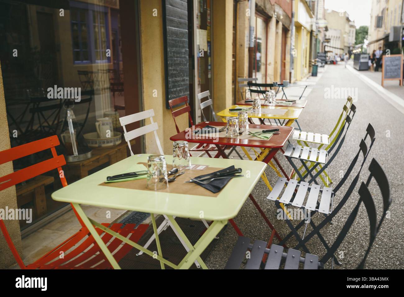 Theme cafes and restaurants. Exterior summer terrace of bright colors of street cafe shop in Europe in France. Preserved tables Without people, at tab Stock Photo