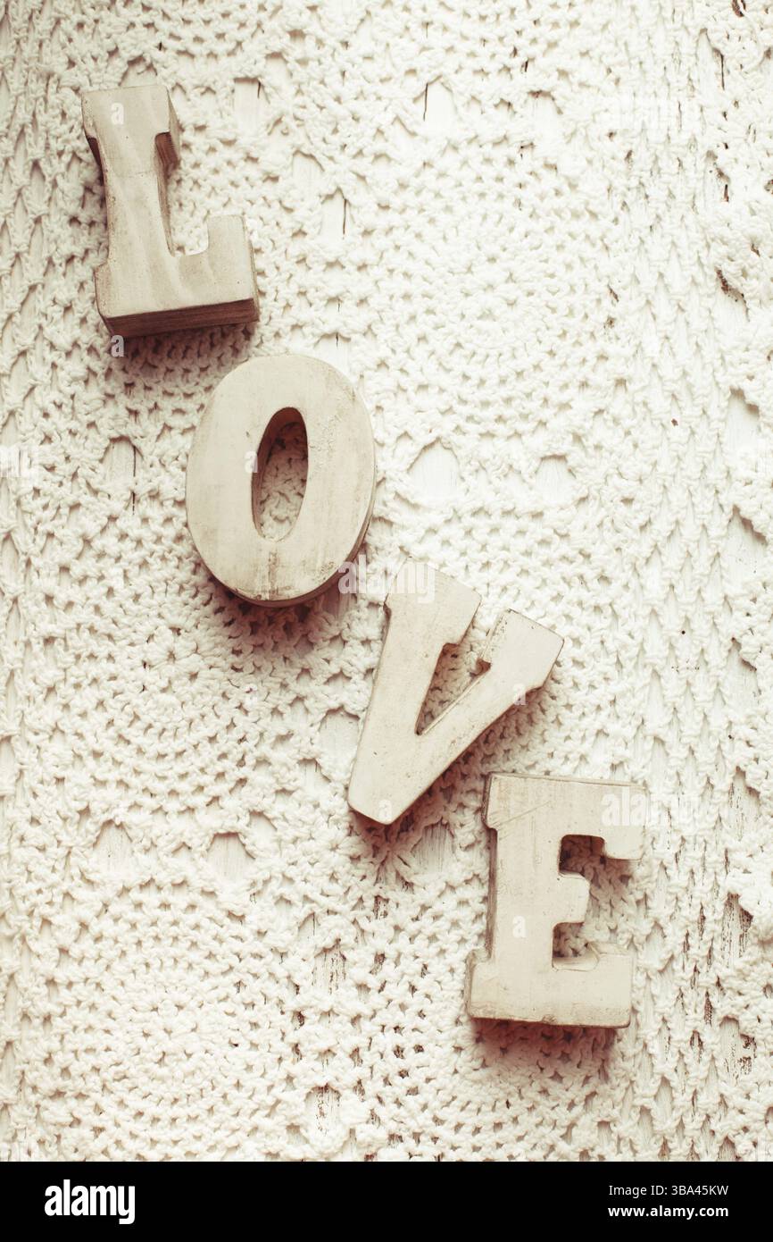 Love wooden letters on the crochet doily, vintage styled Stock Photo