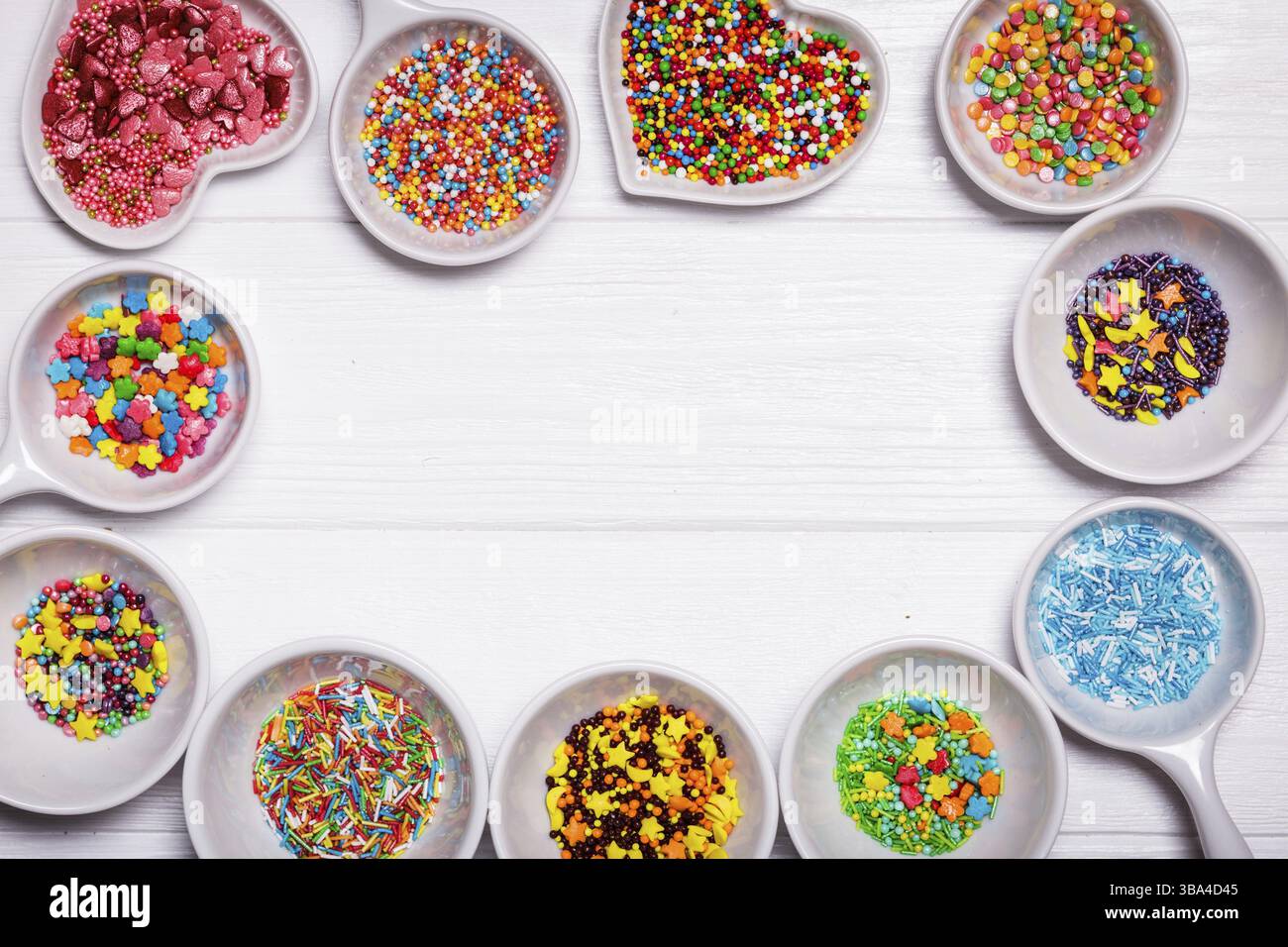 Various color sprinkles in a white bowls Stock Photo - Alamy