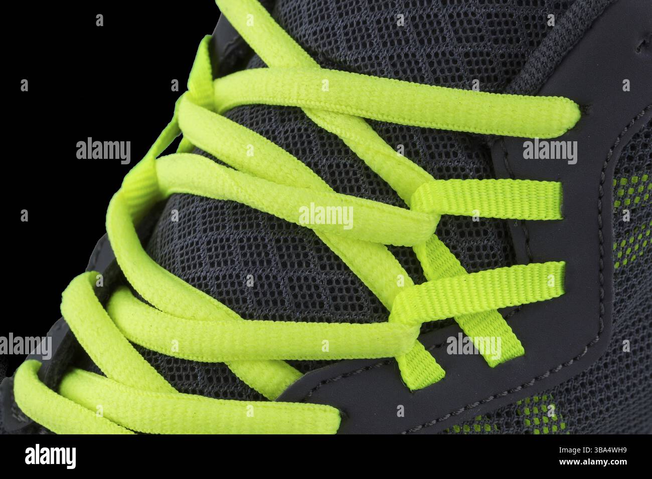 Fragment of black sneaker with green laces close up. Sneaker texture Stock Photo