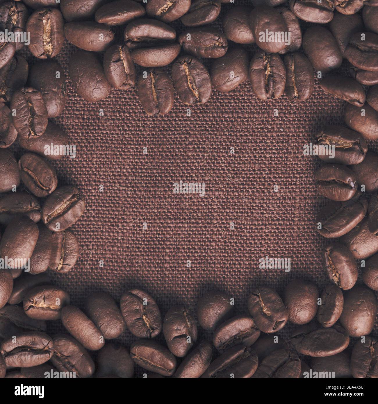 Spilled coffee beans frame over linen textile Stock Photo