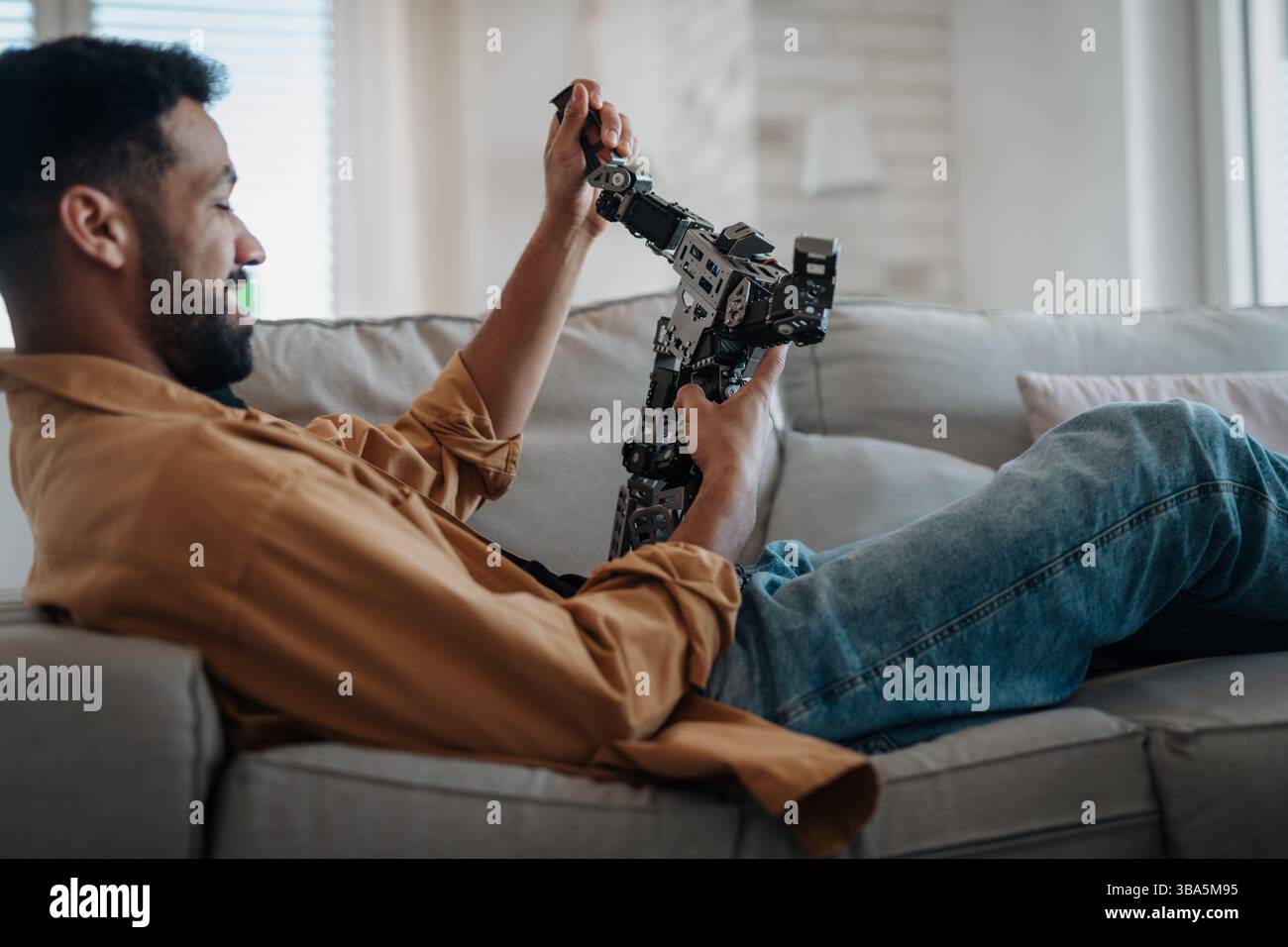Handsome engineer student working on robot project at home. Stock Photo